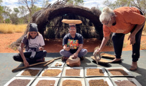 Kitana with a coolamon – a traditional vessel for carrying bush foods as well as babies – at the cultural workshop.